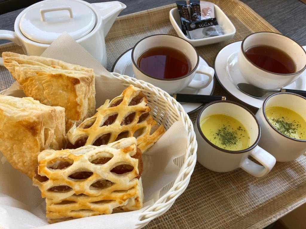 - une table avec un panier de pain et deux tasses de thé dans l'établissement Hotel Chateau Briant (Adult only), à Saitama