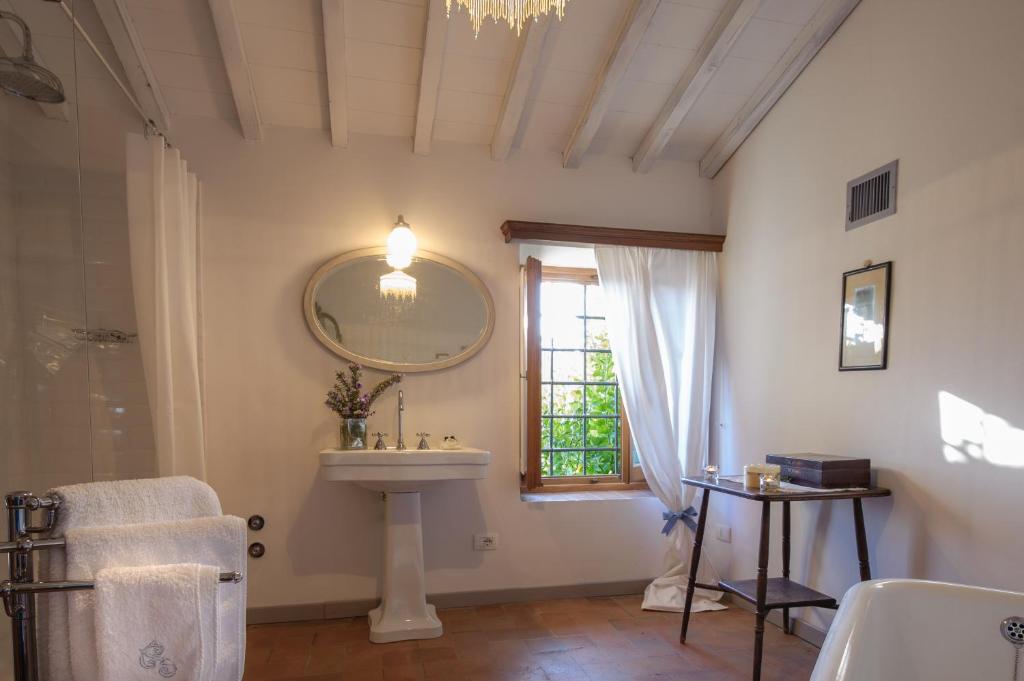 une salle de bain avec un lavabo, un miroir et une fenêtre dans l'établissement Chiantivillas Villa Torricella, 27, à Tavarnuzze