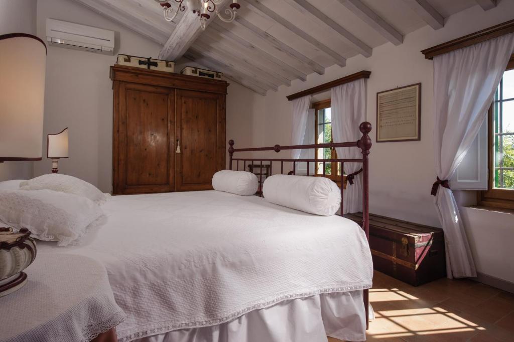 une chambre avec un grand lit avec des draps blancs dans l'établissement Chiantivillas Villa Torricella, 27, à Tavarnuzze 23 autres photos