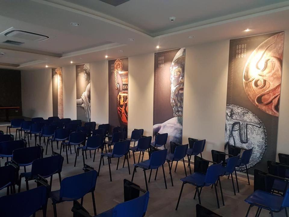 une chambre avec des chaises et des affiches sur les murs dans l'établissement Aerhotel Phelipe, à SantʼEufemia Lamezia