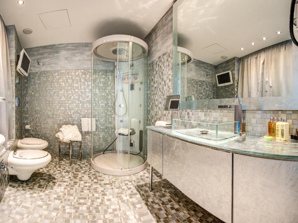 une salle de bain avec une douche, des toilettes et un lavabo dans l'établissement Hotel Waldorf- Premier Resort, à Milano Marittima