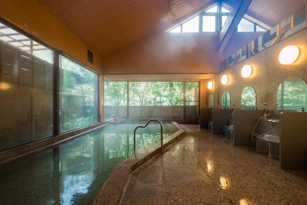 une chambre avec une piscine dans un bâtiment dans l'établissement Yamagaso, à Hakone