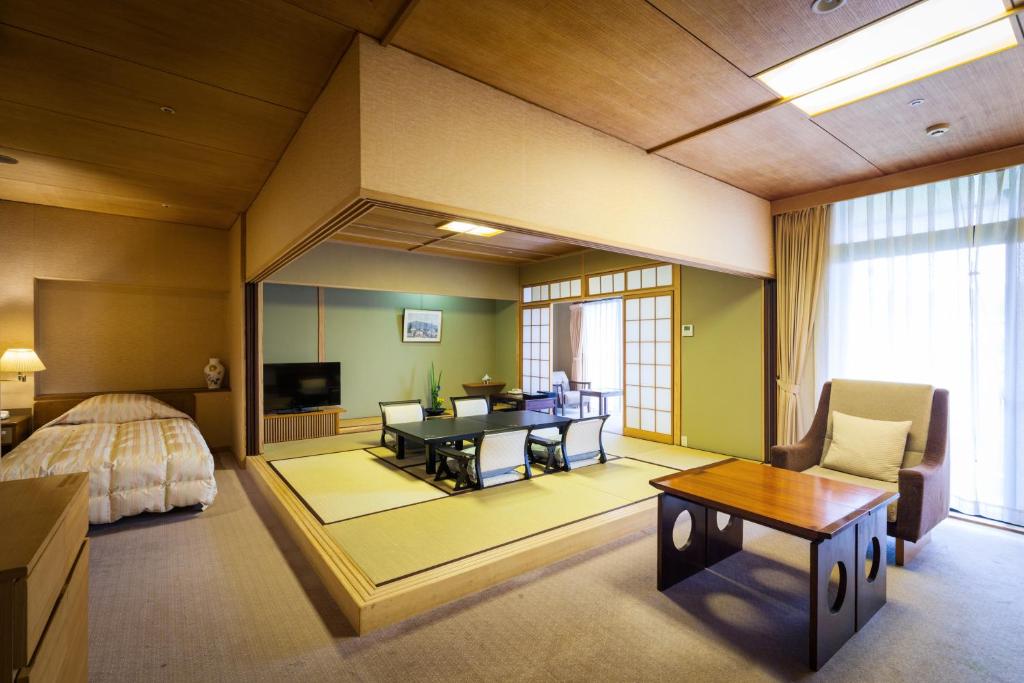 une chambre avec un lit, un bureau et une table dans l'établissement Funaya, à Matsuyama