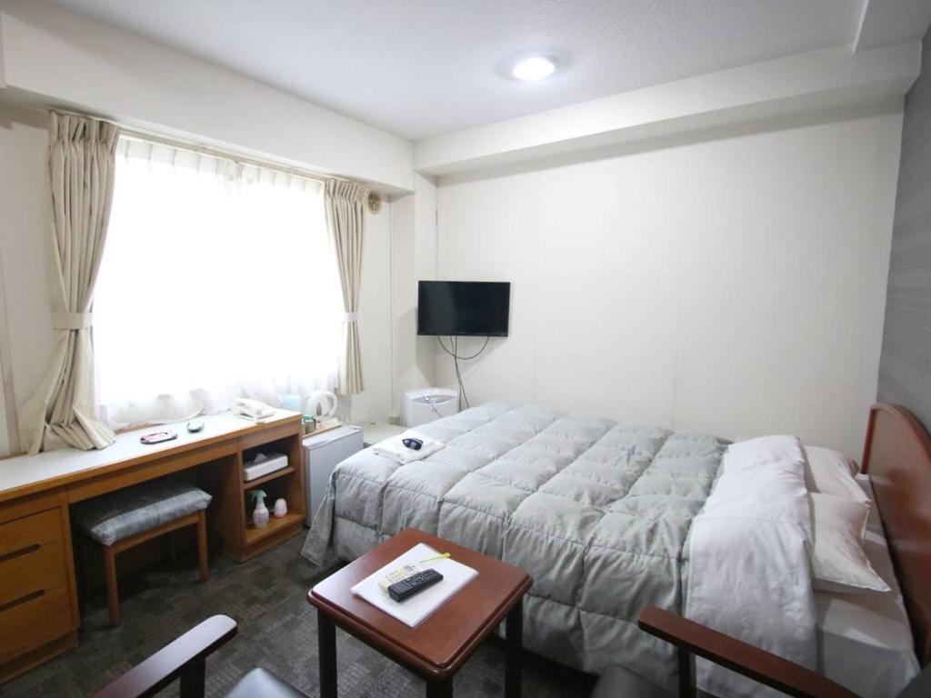 une chambre d'hôtel avec un lit, une table et un bureau dans l'établissement Itoen Hotel Inatori, à Inatori 33 autres photos