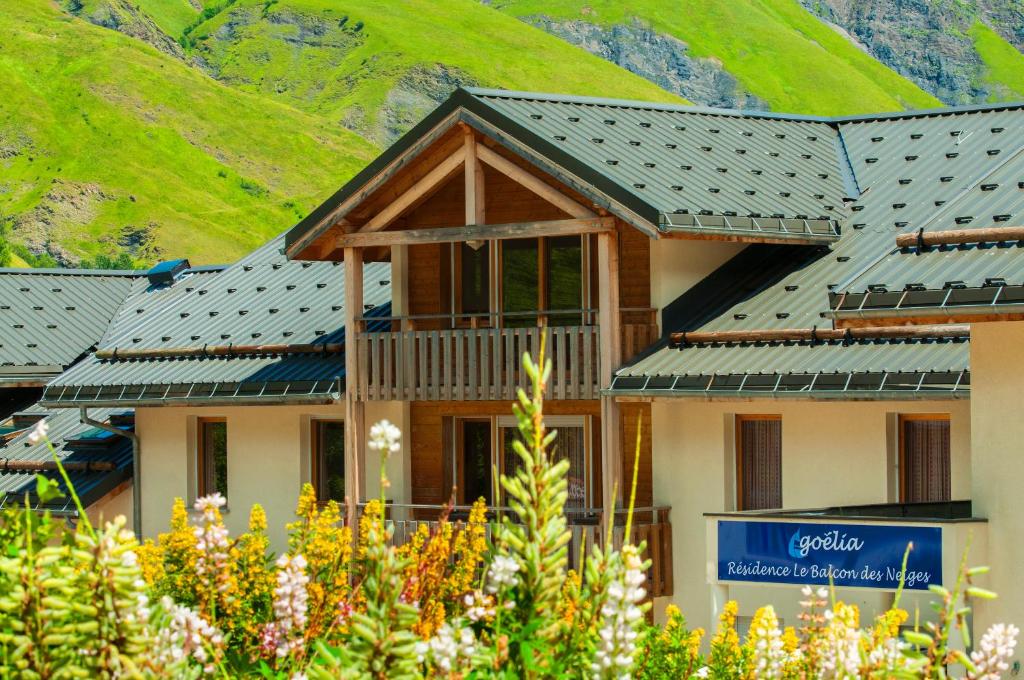 un bâtiment avec une montagne en arrière-plan dans l'établissement Résidence Goélia Le Balcon des Neiges, à Saint-Sorlin-dʼArves