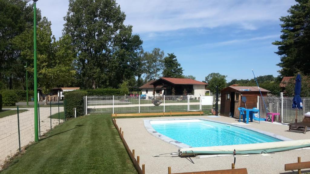 une piscine dans une cour clôturée dans l'établissement Paradis Des Dombes, à Sandrans