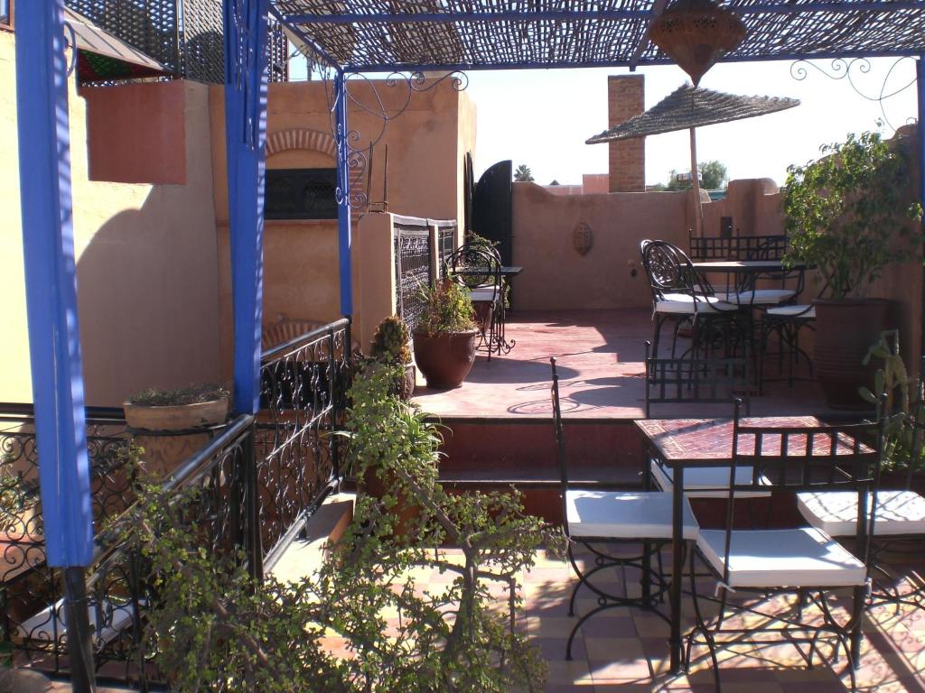 un patio extérieur avec tables, chaises et plantes dans l'établissement Riad Hiba, à Marrakech