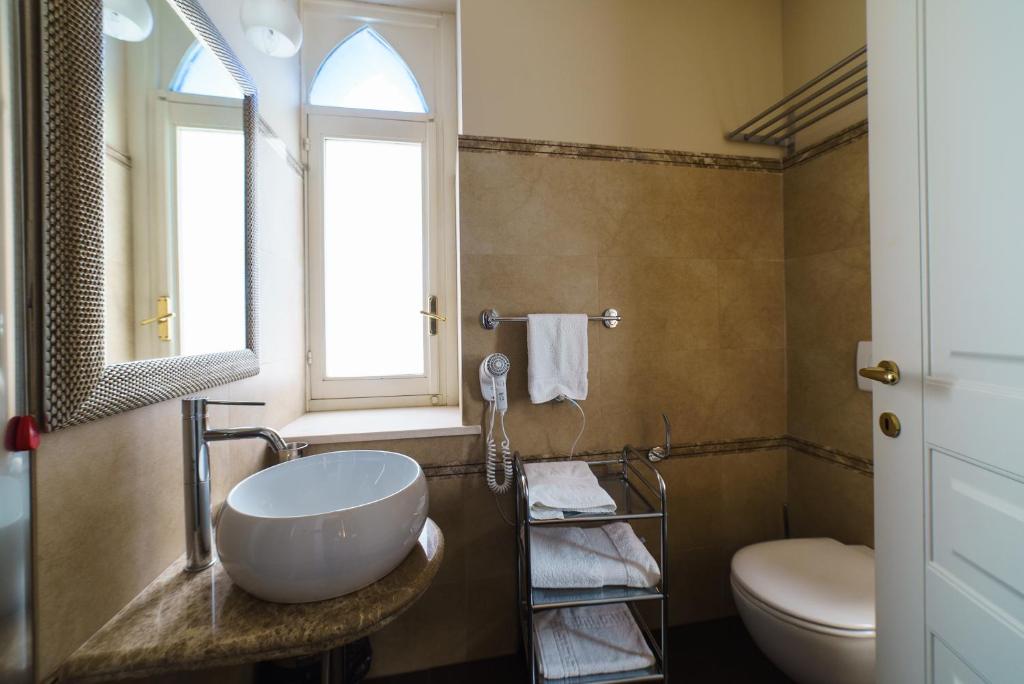 une salle de bain avec un lavabo et des toilettes et une fenêtre dans l'établissement Relais La Placa, à Francavilla di Sicilia 28 autres photos