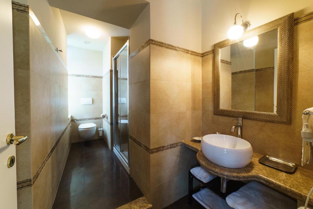 une salle de bain avec un lavabo et des toilettes dans l'établissement Relais La Placa, à Francavilla di Sicilia