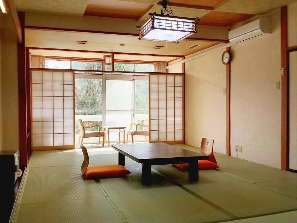 une pièce avec une table, des chaises et une fenêtre dans l'établissement Hotel Yumoto, à Utsuno 21 autres photos