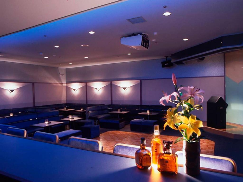 - une salle à manger avec des tables, des chaises et des fleurs sur une table dans l'établissement Hotel Yumoto, à Utsuno