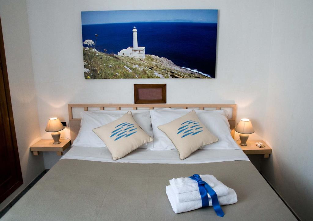 - une chambre avec un lit avec deux oreillers et un phare dans l'établissement Villa Conca D'oro, à Gallipoli