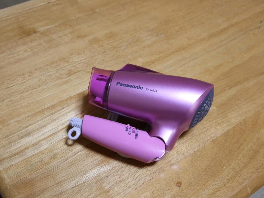 un sèche-cheveux violet assis sur une table en bois dans l'établissement Minshuku Unzen, à Unzen
