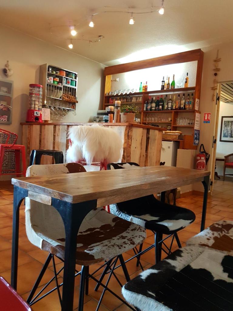 - une table en bois dans une chambre avec 2 chaises dans l'établissement Hôtel Yaka, aux Angles
