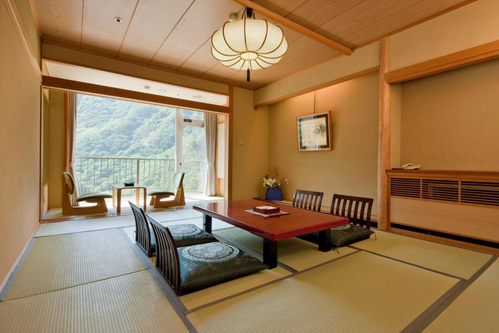 une salle à manger avec une table et une grande fenêtre dans l'établissement Marumine Kanko Hotel, à Aizuwakamatsu