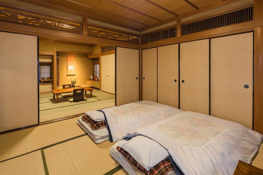 une chambre avec un grand lit dans une pièce dans l'établissement Kamuroan, à Kyoto
