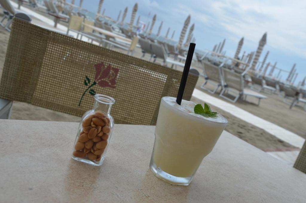 - une boisson assise sur une table à côté d'une bouteille de boisson dans l'établissement Hotel Rosen Garden, à Milano Marittima