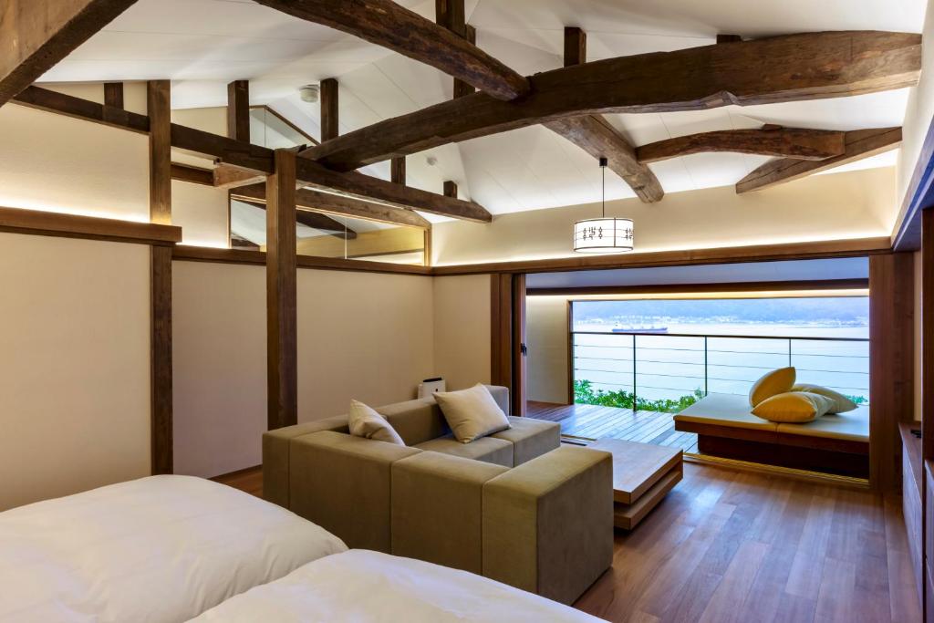 une chambre avec un lit et un canapé dans l'établissement Genmyoan, à Miyazu