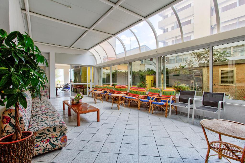 une véranda avec des tables et des chaises dans un bâtiment dans l'établissement Hotel Delle Nazioni - Valentini Family Village, à Bellaria-Igea Marina