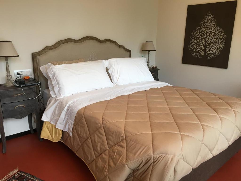 une chambre avec un grand lit avec des oreillers blancs dans l'établissement Villa Oliveto, à Padenghe sul Garda