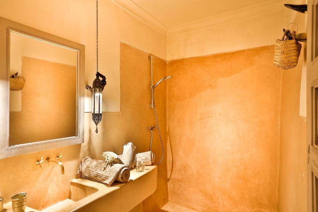 une salle de bain avec un lavabo et un miroir dans l'établissement Hotel & Spa Riad Al Jazira, à Marrakech