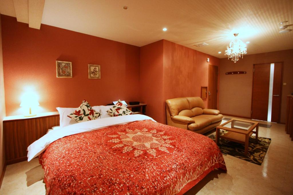 une chambre d'hôtel avec un lit et une chaise dans l'établissement Hotel Aura Resort Ⅰ Kashiba (Adult only), à Kashiba