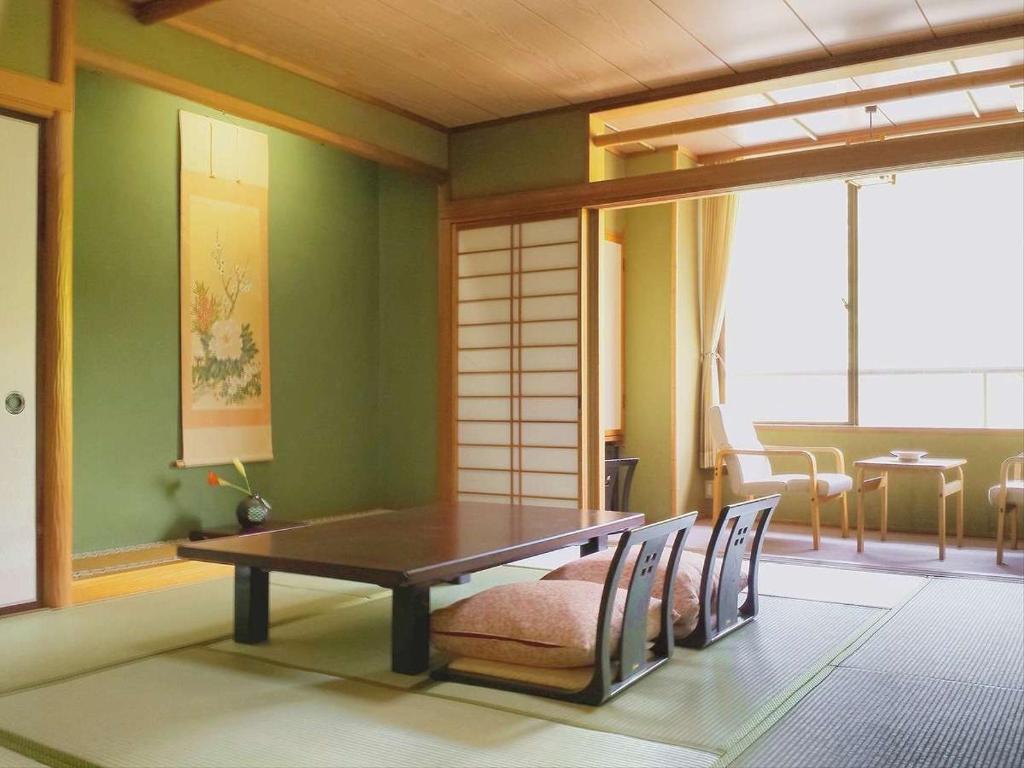 une salle à manger avec une table et quelques chaises dans l'établissement Hotel Yumoto, à Utsuno