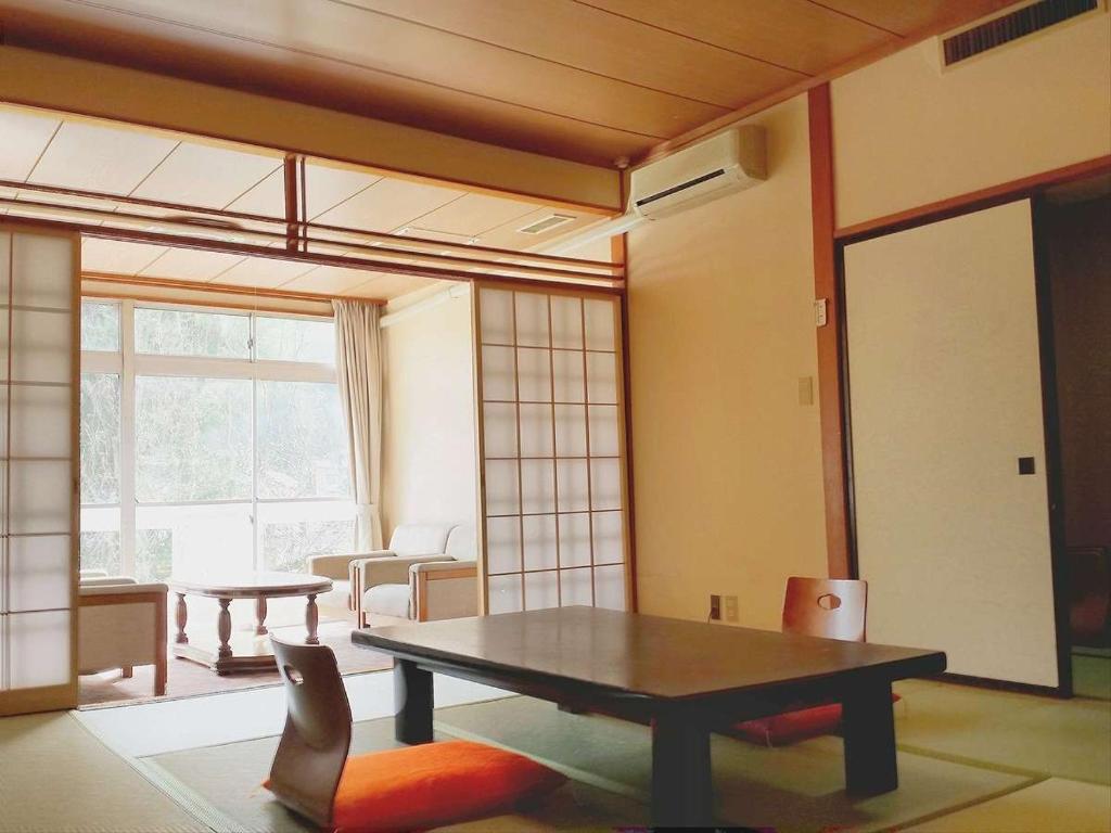 un salon avec une table et une chaise dans l'établissement Hotel Yumoto, à Utsuno