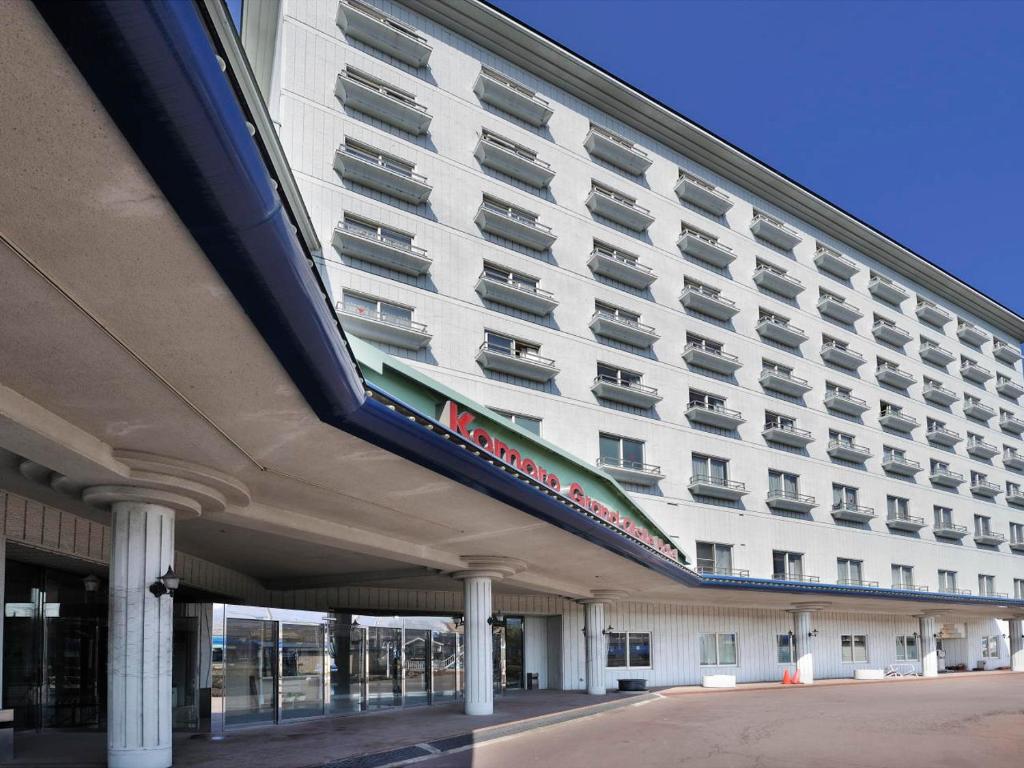 un grand bâtiment blanc avec un panneau latéral dans l'établissement Komoro Grand Castle Hotel, à Komoro