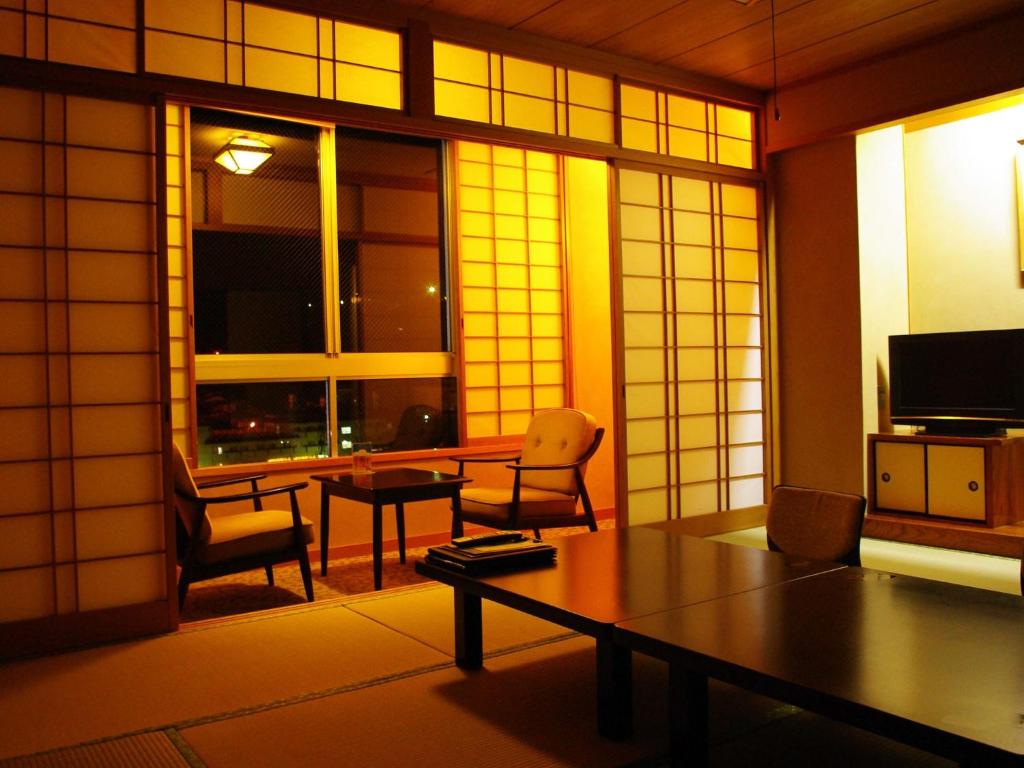 un salon avec une table et des chaises et une fenêtre dans l'établissement Gero Onsen Fugaku, à Gero