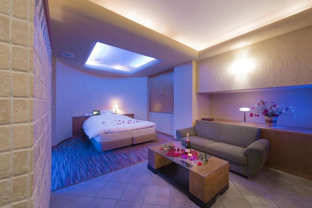 une chambre d'hôtel avec un lit et un canapé dans l'établissement Hotel Chateau Briant (Adult only), à Saitama