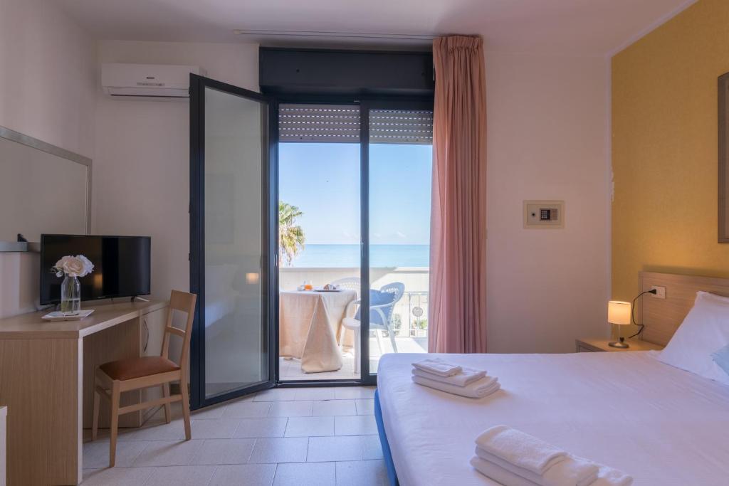 une chambre d'hôtel avec un lit et une vue sur l'océan dans l'établissement Hotel Sole, à Montesilvano