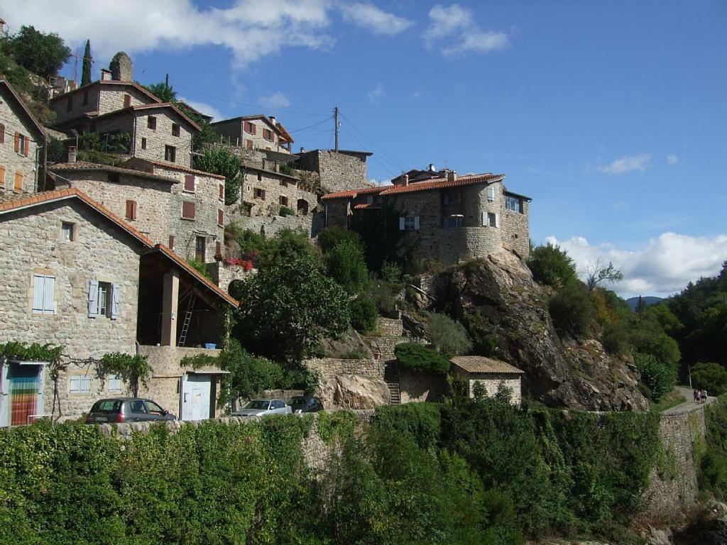 un village sur une colline avec des maisons et des voitures dans l'établissement camping bonneval, à Jaujac