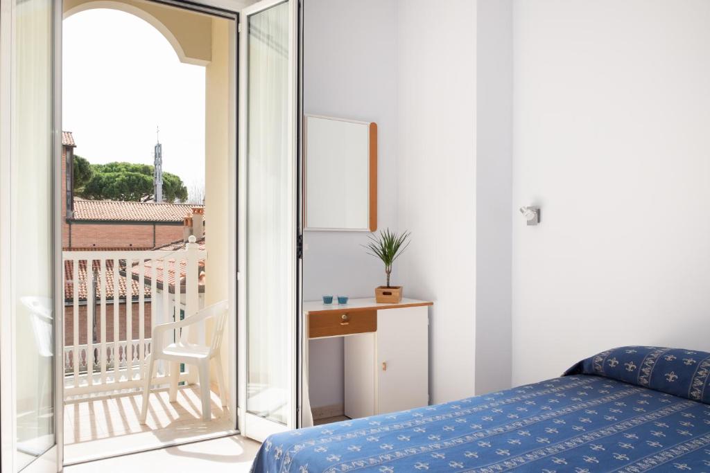 Cette chambre comprend un lit et offre une vue sur un balcon. dans l'établissement Hotel Kadett, à Rimini