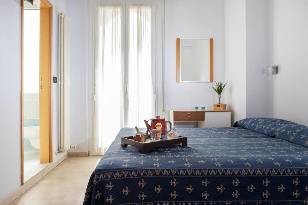 - une chambre avec un lit bleu et un plateau dans l'établissement Hotel Kadett, à Rimini