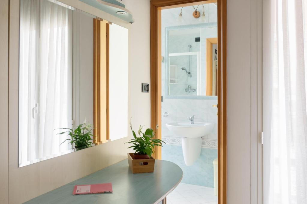 La salle de bains est pourvue d'un lavabo et d'un miroir. dans l'établissement Hotel Kadett, à Rimini