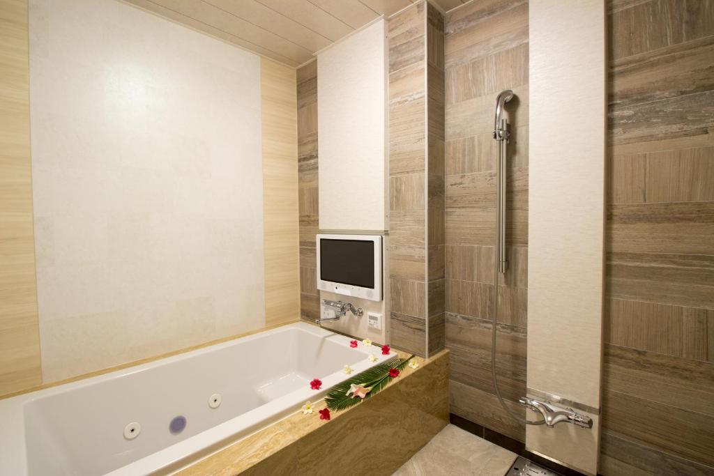 une salle de bain avec une baignoire et une télévision au mur dans l'établissement ホテル アンジュエトワール 堺 - Adult Only, à Sakai