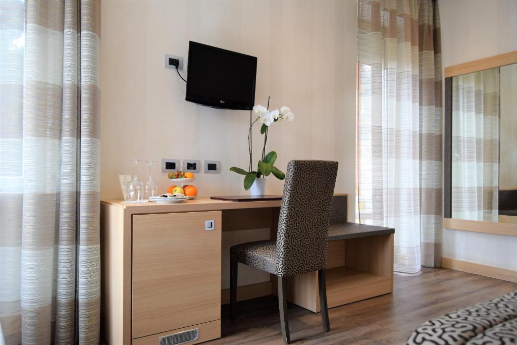 un bureau avec une chaise et une télévision sur un mur dans l'établissement Hotel Continental, à Taormine