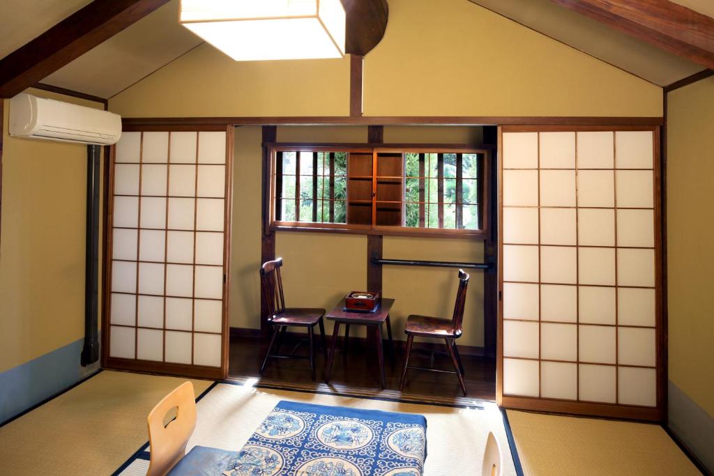 - une chambre avec une table et deux chaises dans l'établissement Ryori Ryokan Tsurugata, à Kurashiki