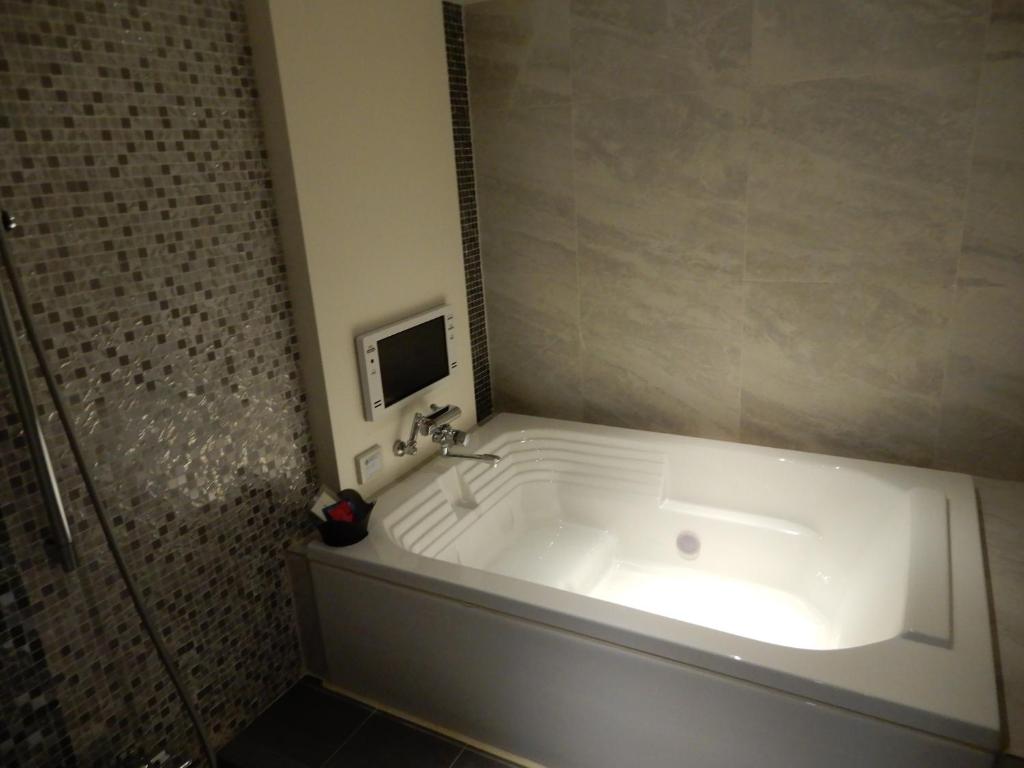 La salle de bains est pourvue d'une baignoire et d'un lavabo. dans l'établissement HOTEL VERSYS (Adult Only), à Hiroshima