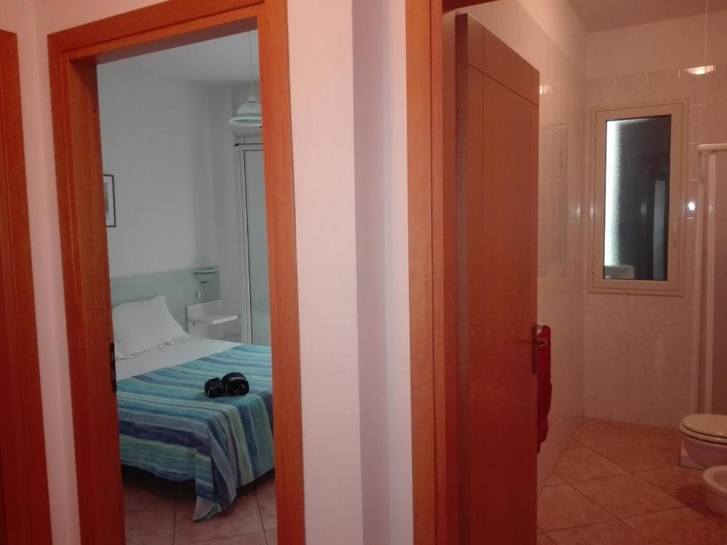 Cette chambre comprend un lit et une porte menant à une chambre. dans l'établissement Residenza Arene, à Gallipoli 74 autres photos