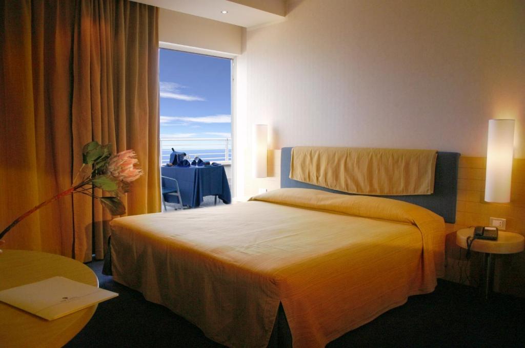 une chambre d'hôtel avec un lit et une grande fenêtre dans l'établissement Nicotel Bisceglie, à Bisceglie