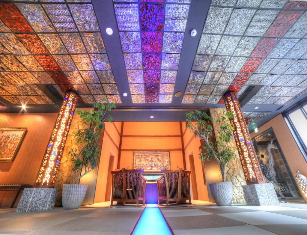 Cette chambre dispose d'un plafond coloré et d'un couloir avec des chaises. dans l'établissement Balinese onsen ryokan Hakone Airu, à Hakone
