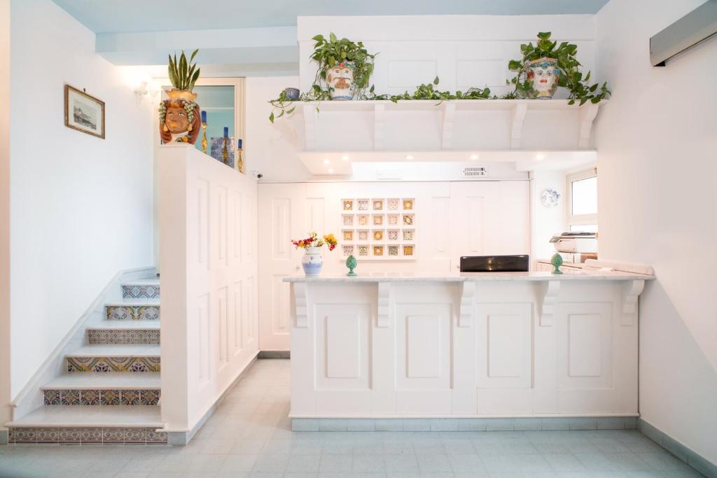 une cuisine avec un comptoir avec des plantes sur le mur dans l'établissement Hotel Villa Nefele, à Giardini Naxos