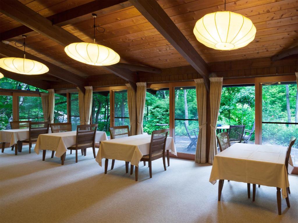 une salle à manger avec tables, chaises et fenêtres dans l'établissement Nakaodaira, à Takayama