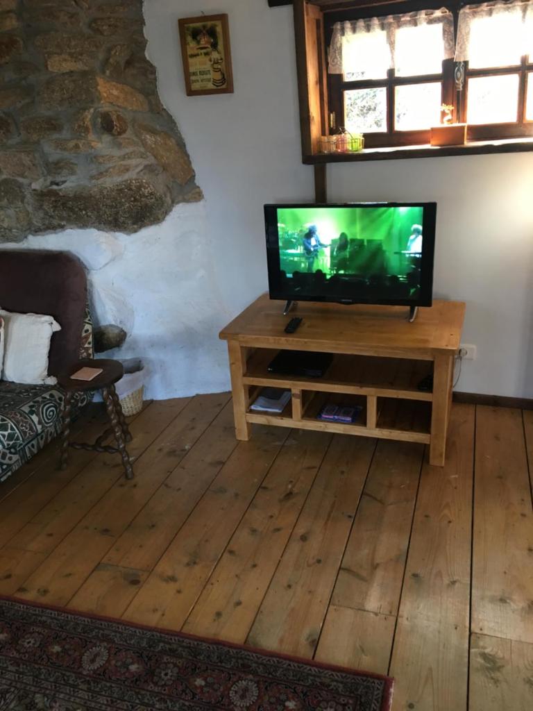 un salon avec une télévision à écran plat sur une table en bois dans l'établissement Gîtes de Camors, à Camors