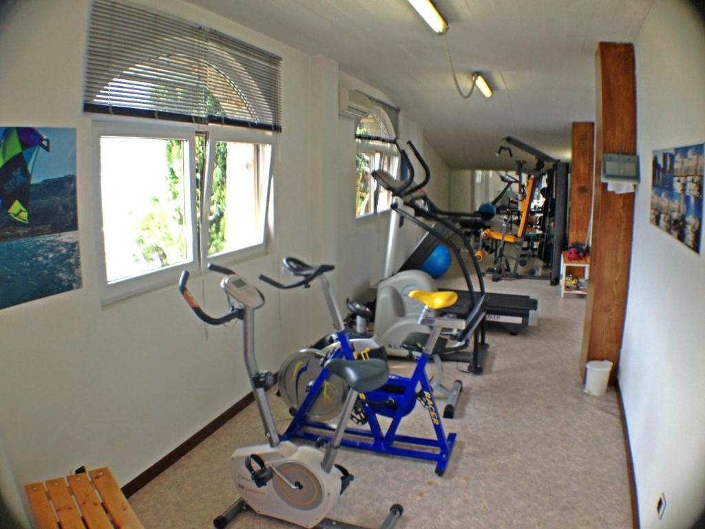 une salle de sport avec plusieurs vélos d'exercice dans une pièce dans l'établissement Hotel Villa Carmen, à Malcesine