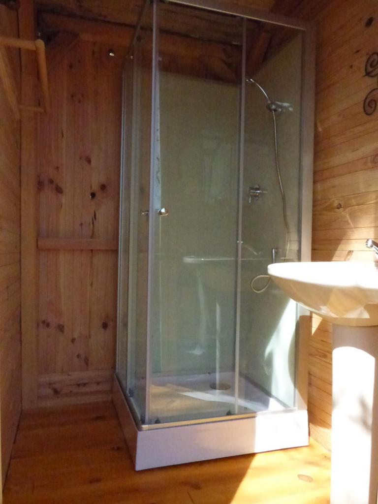 une douche en verre dans une salle de bain avec un lavabo dans l'établissement D'tente sky lodge, à Massat