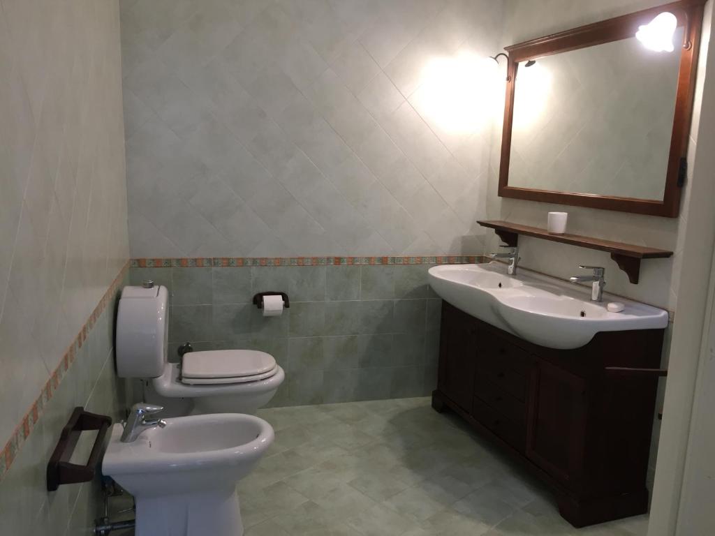 une salle de bain avec un lavabo, des toilettes et un miroir dans l'établissement Villa Terrauzza, à Syracuse 24 autres photos