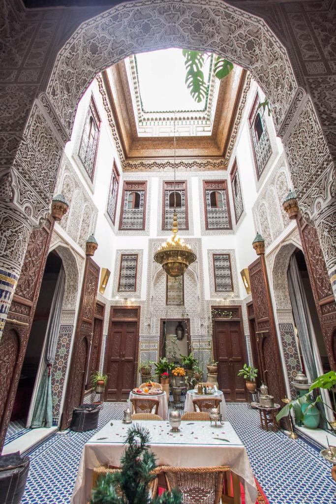 une grande chambre avec tables dans un bâtiment avec plafond dans l'établissement Riad Dar Cordoba, à Fès